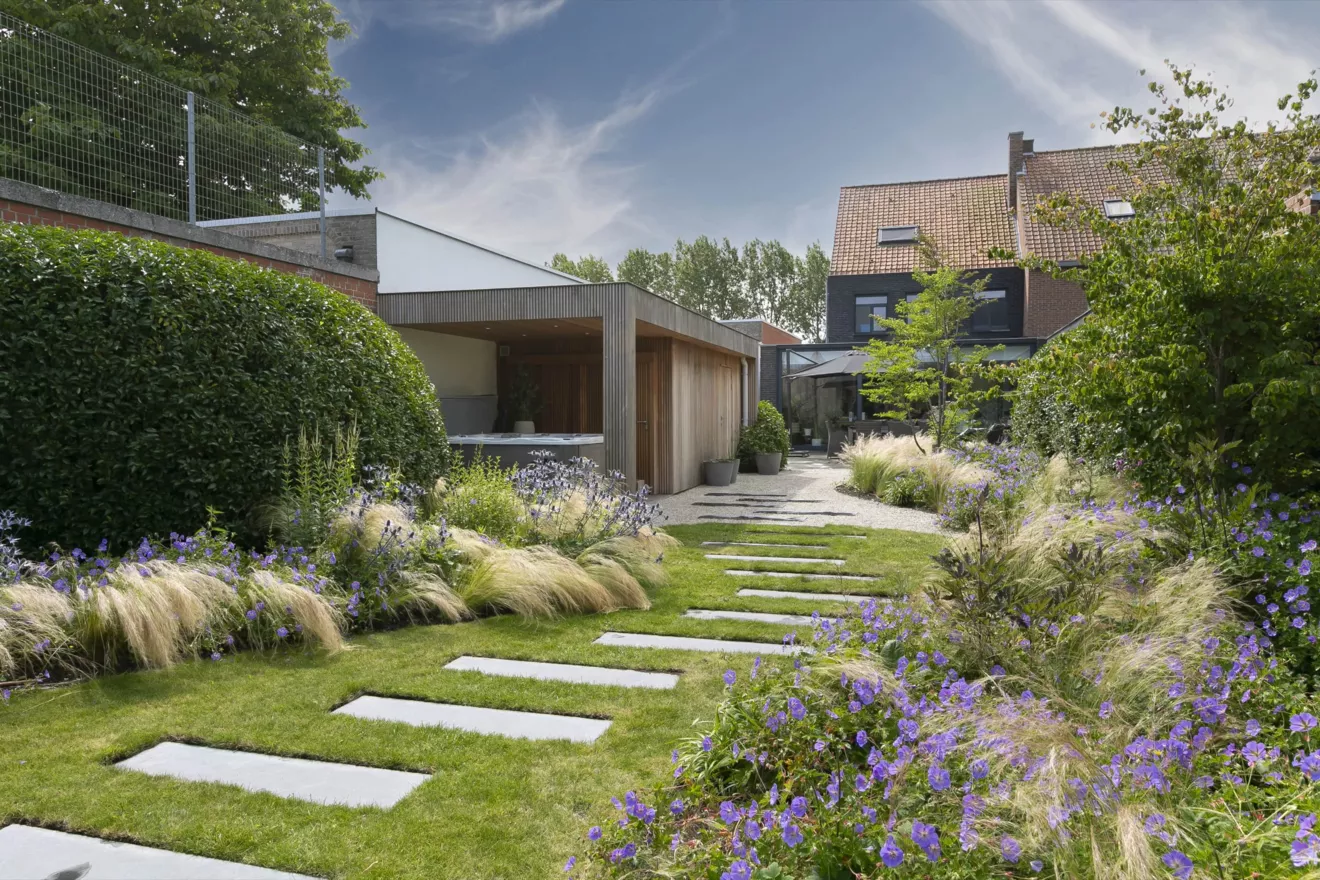 Speelse kusttuin met Dutchborder vol bloemenpracht en tuinberegening te Oostduinkerke (2) -  - Tuinaanleg