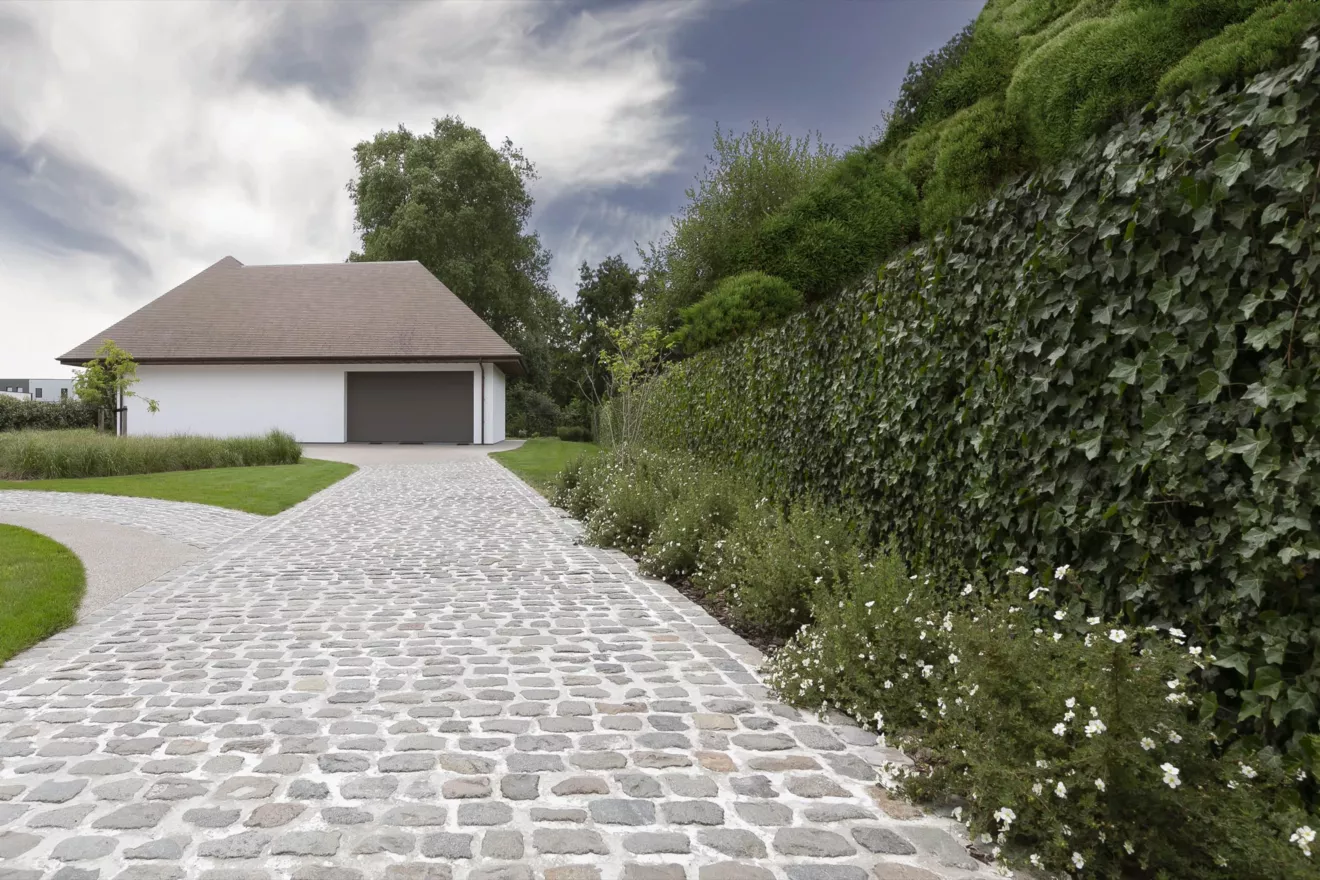 Villatuin te Oostduinkerke met oprit in porfier, uitgewassen beton en kleurrijke borders (3) -  - Tuinaanleg