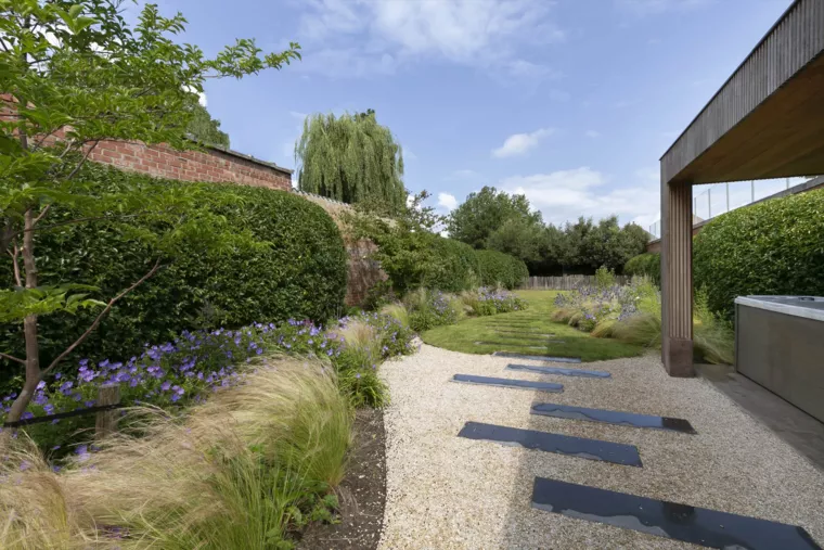 Speelse kusttuin met Dutchborder vol bloemenpracht en tuinberegening te Oostduinkerke (1) - 